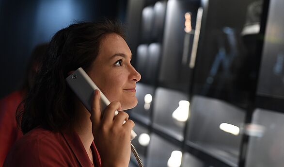 Besucherin mit Hörstation in der Ausstellung Archäologie in Baden
